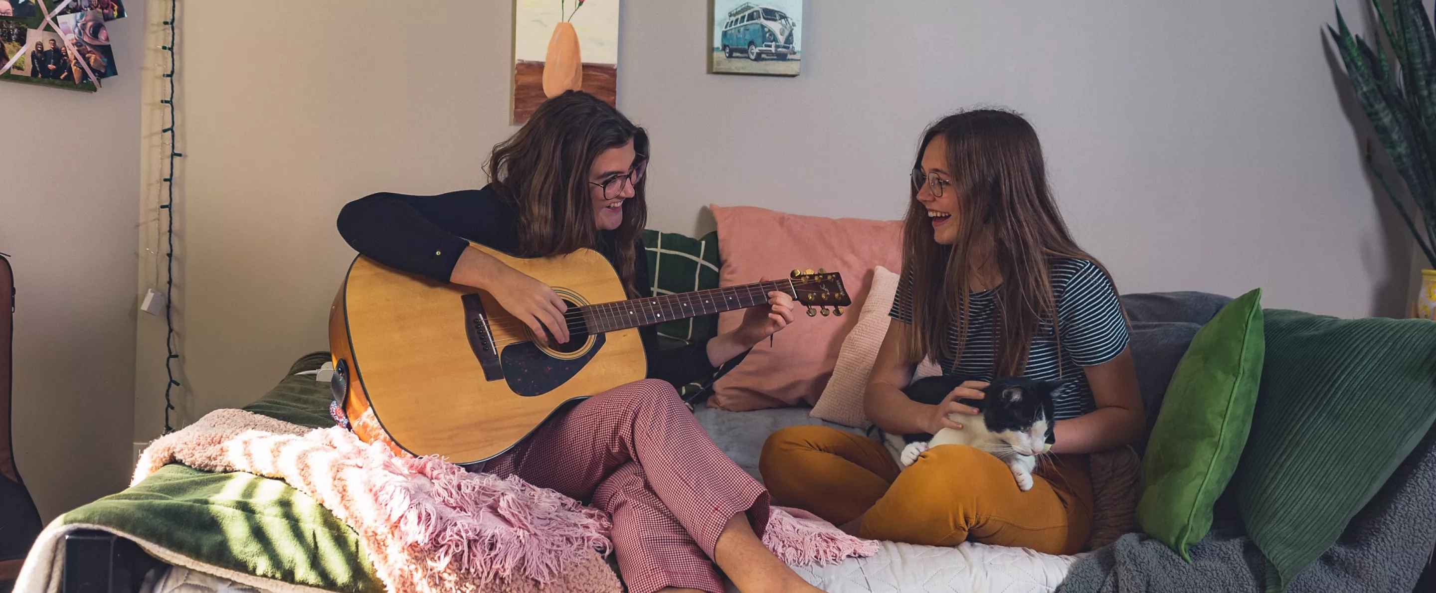 Music  therapy majors Caroline Rushing and Mackenzie Aldridge entertain each other in the Rose Anna Hughes Home room they share with cat Louie.