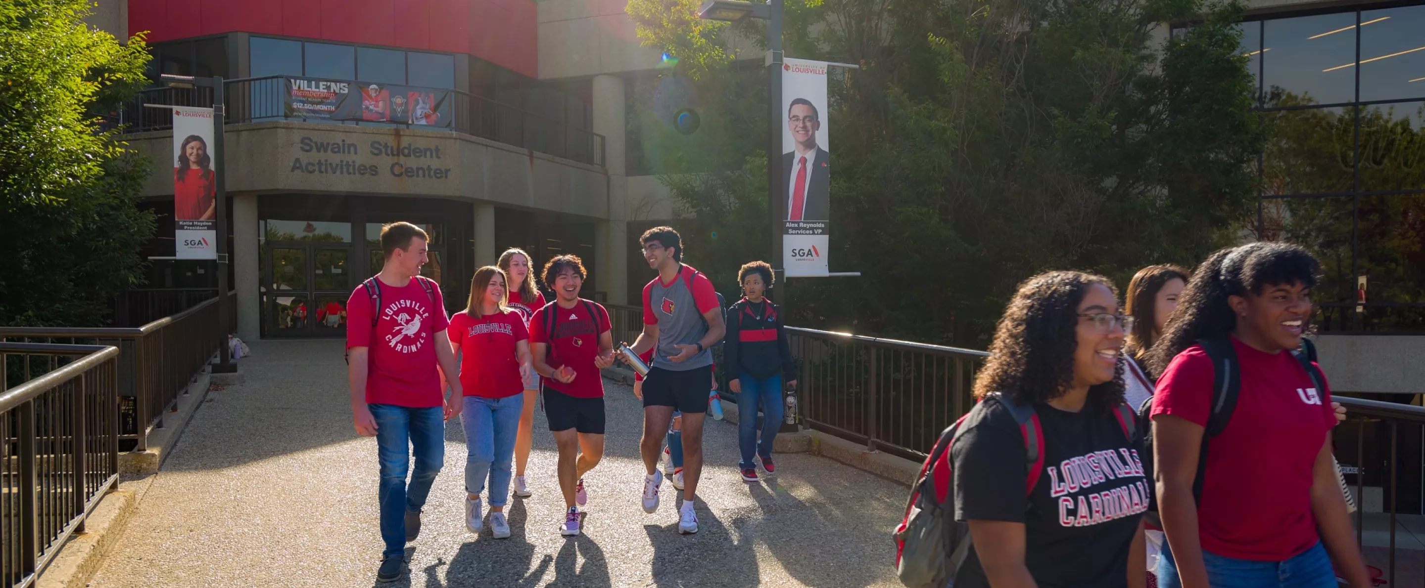 A group of students exiting the Student Activities Center on a sunny morning