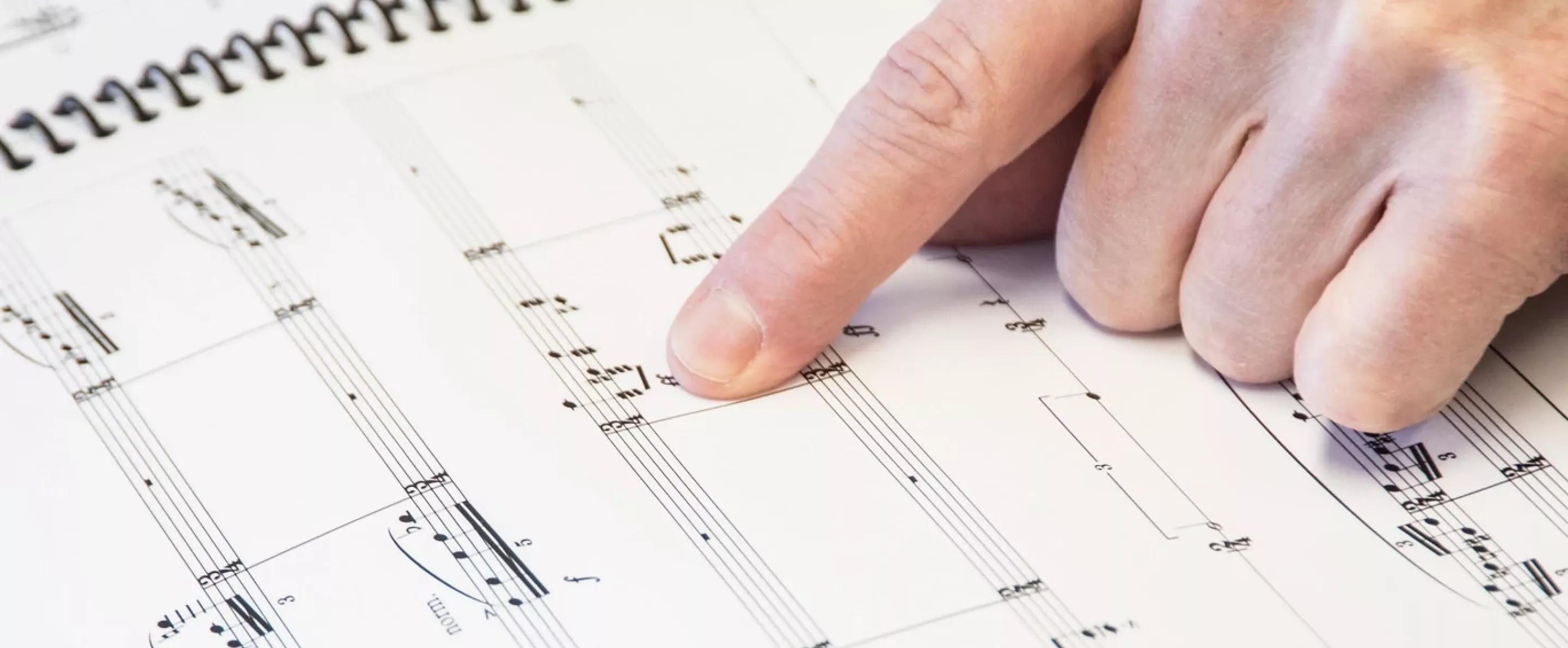 A hand pointing out music notes