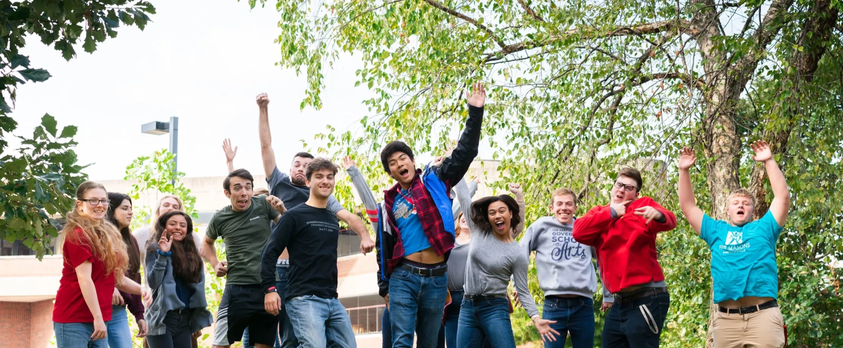 Students outside School of Music jumping