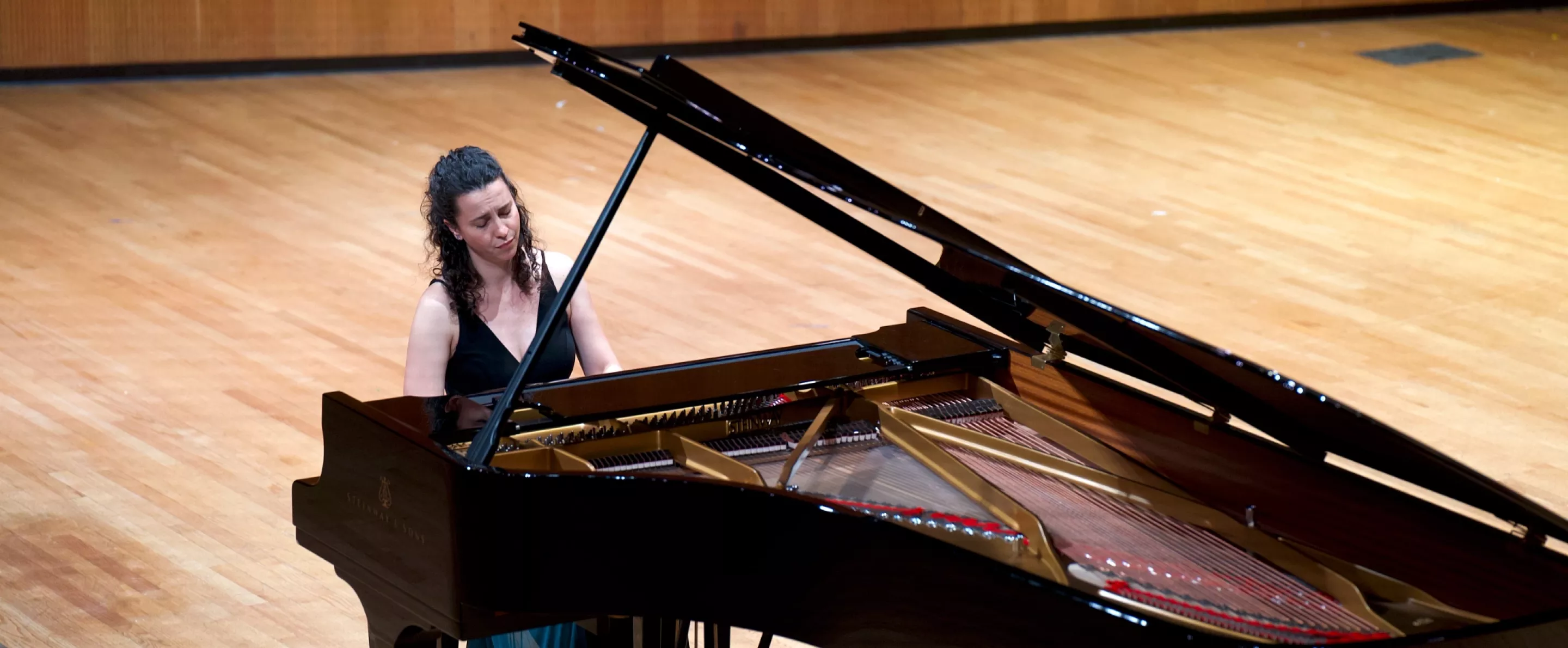 Faculty member playing piano on Comstock stage