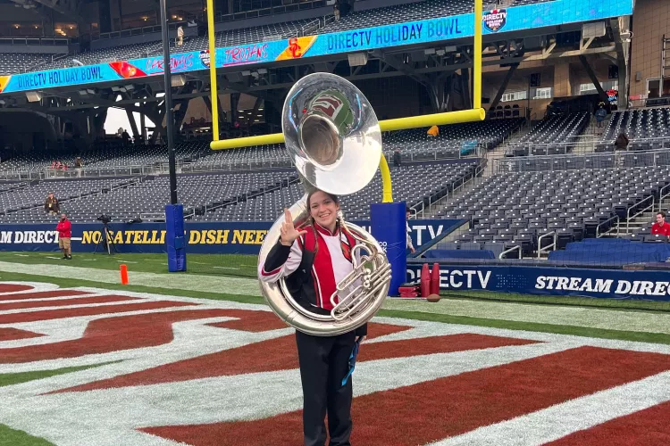 Student with instrument on football field