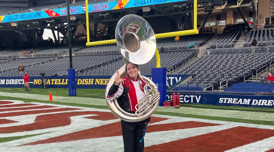Student with instrument on football field