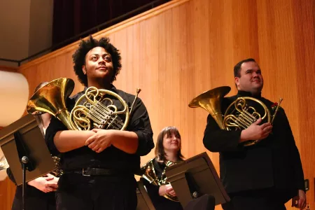 Students standing with their french horns
